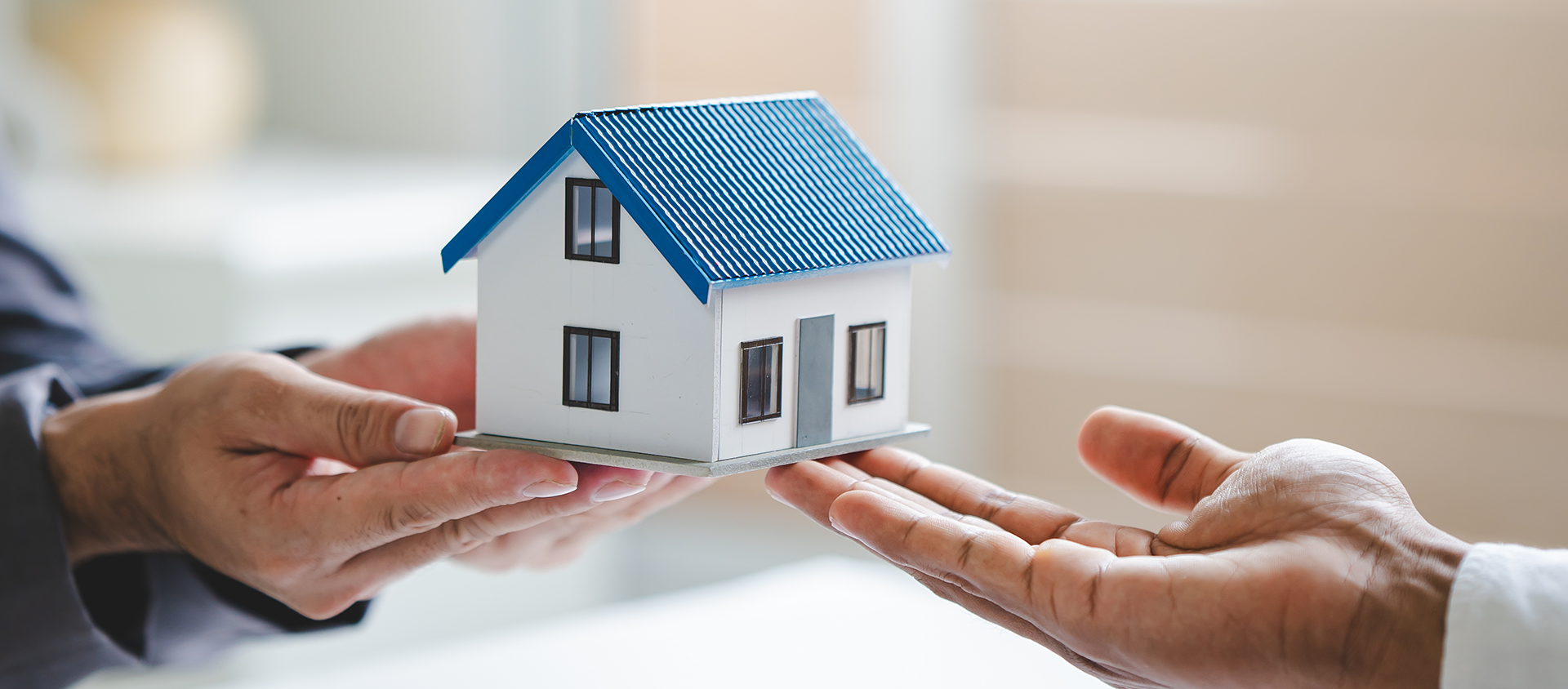 Man handing over model of house